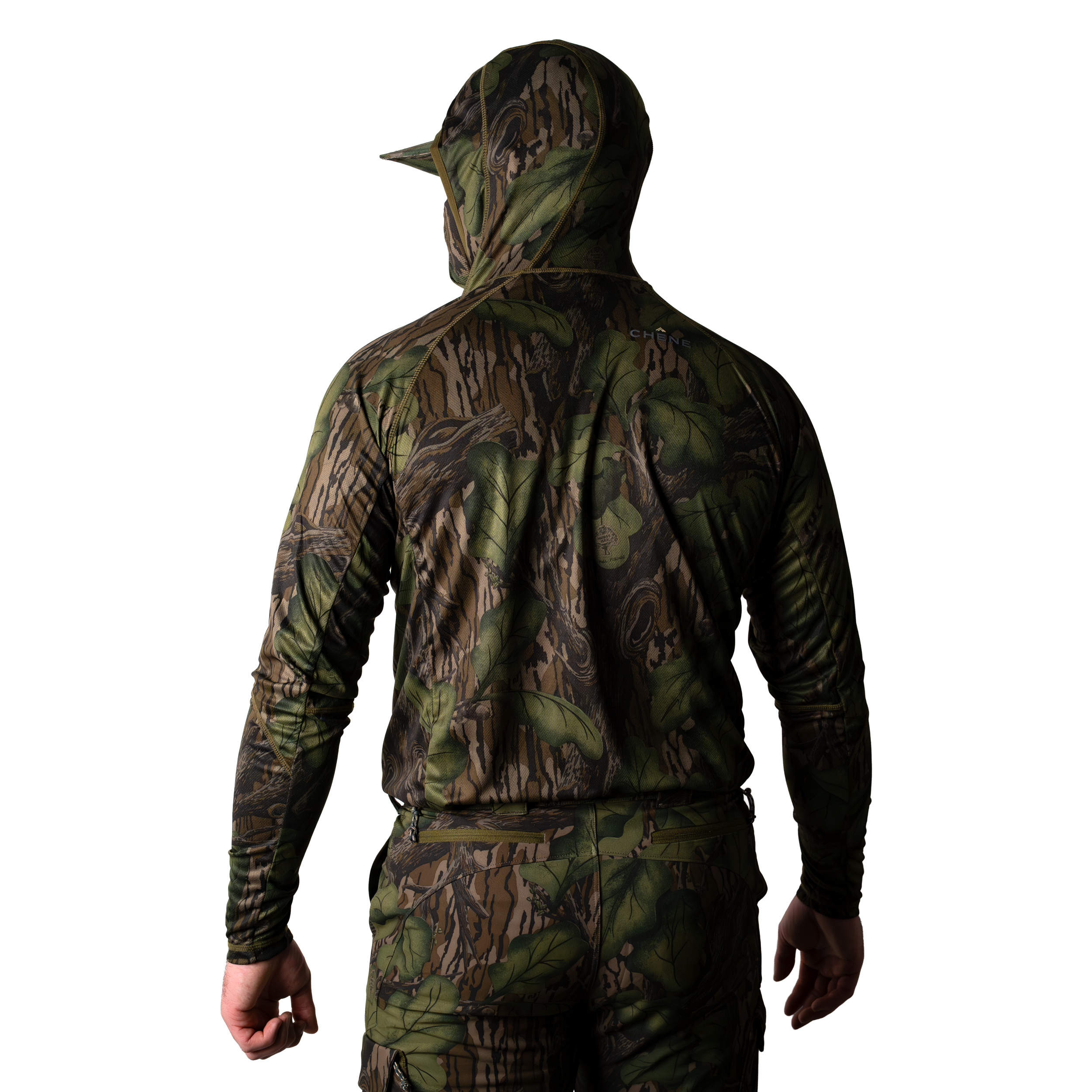 Model wearing a green and brown camouflage hoodie with built in face mask and brimmed cap, back body view on light background. #mossy_oak_full_foliage