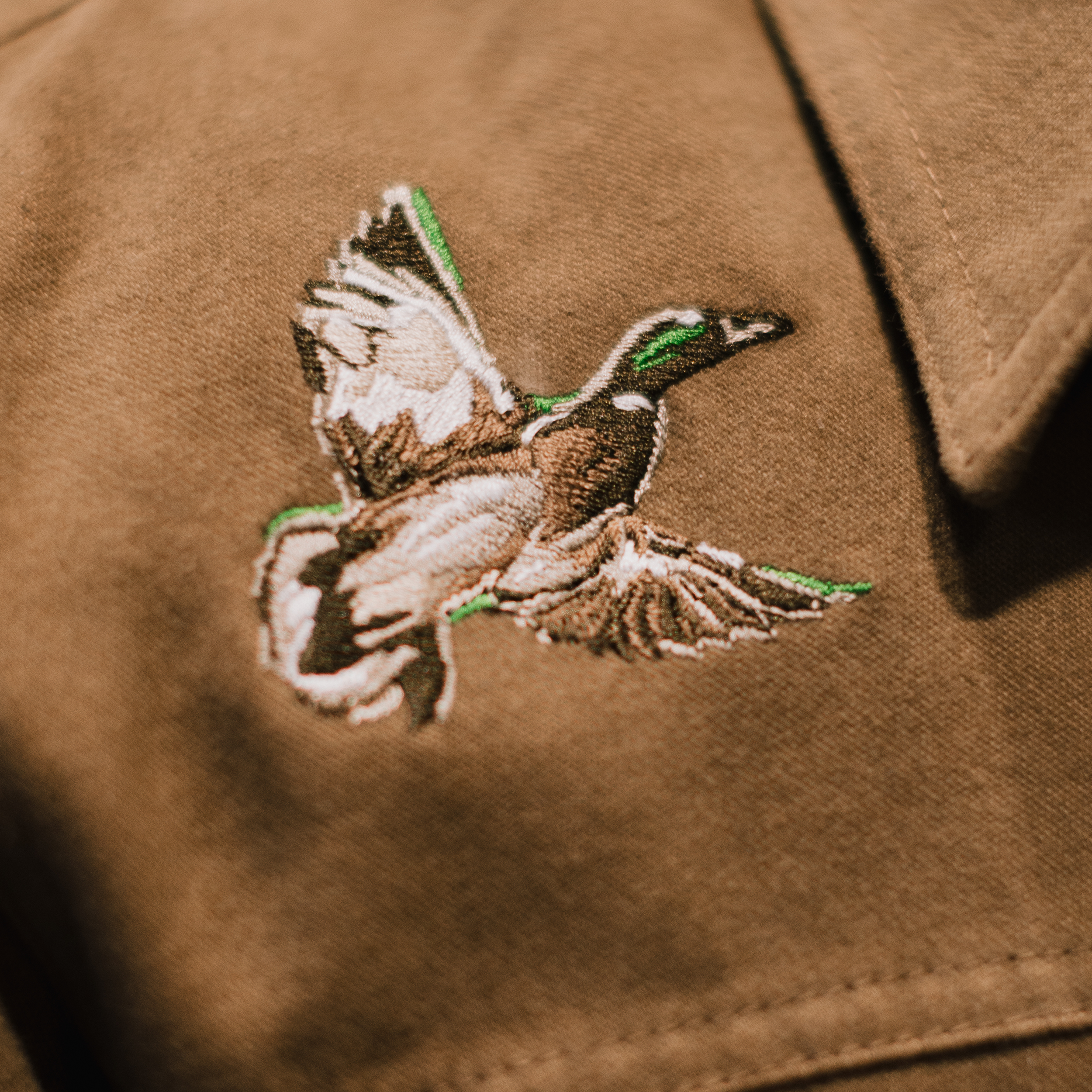 Brown jacket with an embroidered duck design on a brown background #all