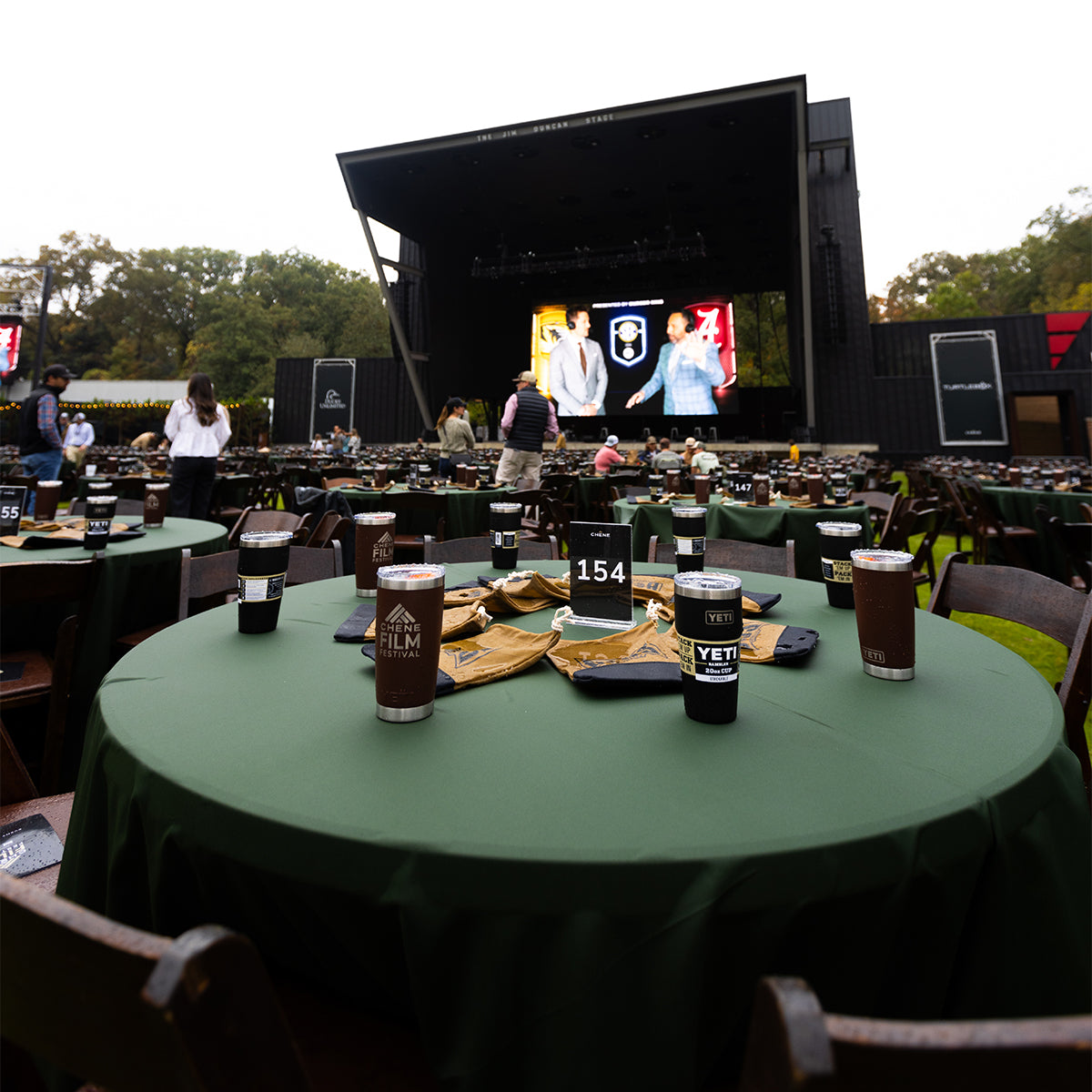 A private table at an event with place settings, dishes, and drinks arranged for eight guests, marked with a 'SVIP' sign in the center.
