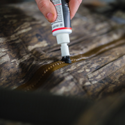 a hand holding a tube of black liquid
