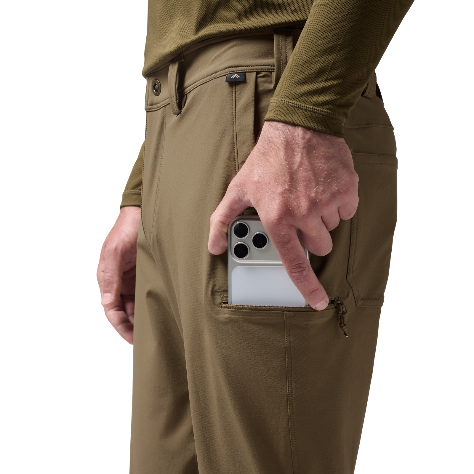 Person wearing tan pants with a camouflage shirt, holding a phone in a pocket. #field_khaki