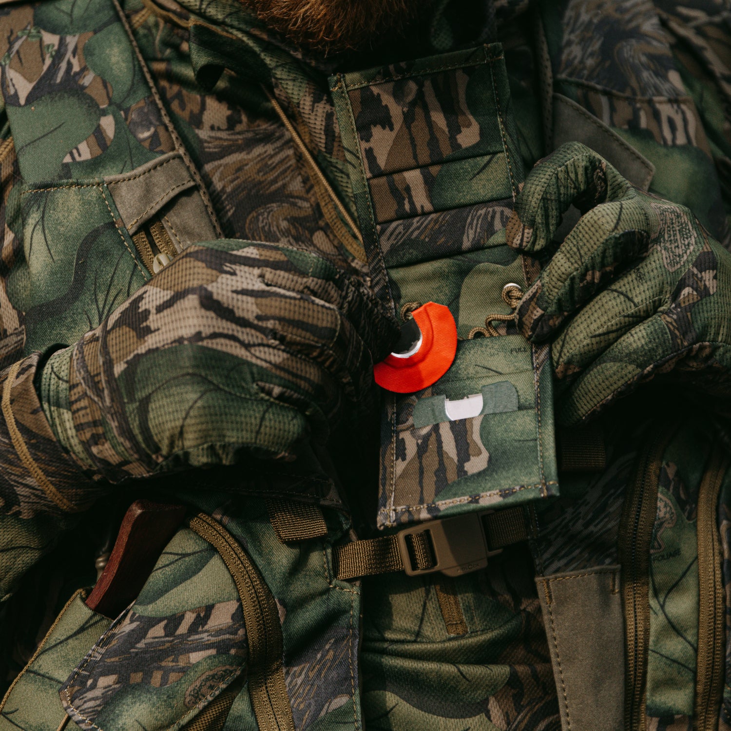 Person wearing camouflage gear with a turkey mouth call 
